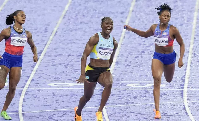 Julien Alfred, of Saint Lucia, crosses the finish line ahead of Sha'carri Richardson, of the United States, and Melissa Jefferson, of the United States, to win the women's 100 meters final at the 2024 Summer Olympics, Saturday, Aug. 3, 2024, in Saint-Denis, France. (AP Photo/Martin Meissner)