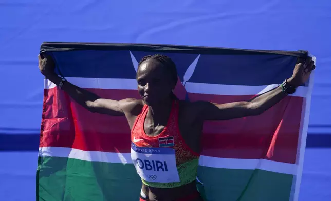 Kenya's Hellen Obiri celebrates after crossing the finish line to win the bronze medal at the end of the women's marathon competition at the 2024 Summer Olympics, Sunday, Aug. 11, 2024, in Paris, France. (AP Photo/Dar Yasin)