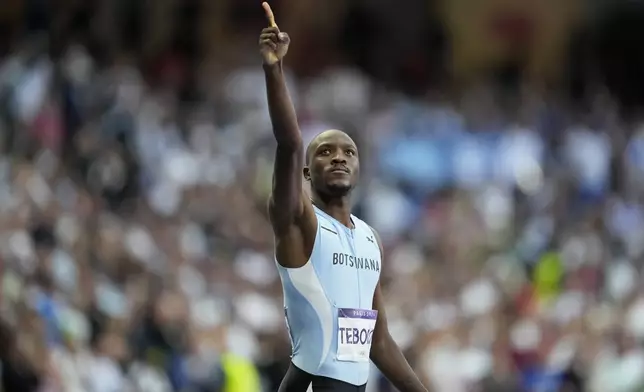 Letsile Tebogo, of Botswana, gestures after winning the gold medal in the men's 200 meters final at the 2024 Summer Olympics, Thursday, Aug. 8, 2024, in Saint-Denis, France. (AP Photo/Ashley Landis)