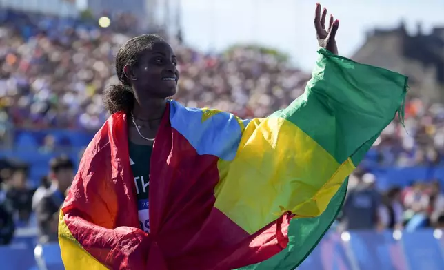 Ethiopia's Tigst Assefa celebrates after crossing the finish line to win the silver medal at the end of the women's marathon competition at the 2024 Summer Olympics, Sunday, Aug. 11, 2024, in Paris, France. (AP Photo/Vadim Ghirda)