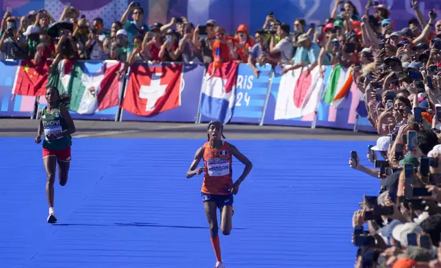 Sifan Hassan, of the Netherlands, right, and Ethiopia's Tigst Assefa, left, approach the finish line at the end of the women's marathon competition at the 2024 Summer Olympics, Sunday, Aug. 11, 2024, in Paris, France. (AP Photo/Dar Yasin)