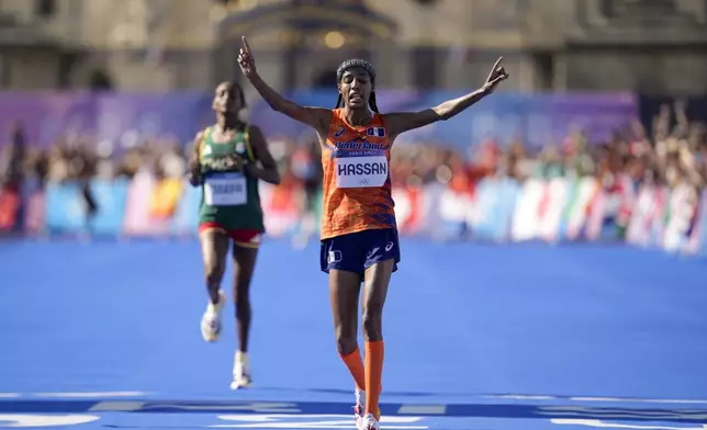 Sifan Hassan, of the Netherlands, celebrates after crossing the finish line to win the gold medal at the end of the women's marathon competition at the 2024 Summer Olympics, Sunday, Aug. 11, 2024, in Paris, France. (AP Photo/Vadim Ghirda)