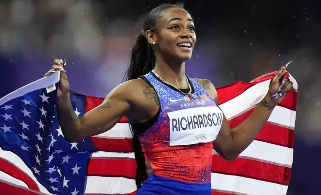 Silver medal winner Sha'carri Richardson, of the United States, smiles after the women's 100-meter final at the 2024 Summer Olympics, Saturday, Aug. 3, 2024, in Saint-Denis, France. (AP Photo/Petr David Josek)