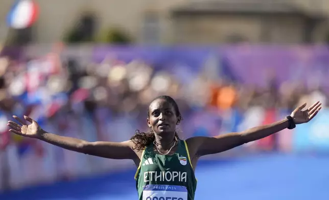 Ethiopia's Tigst Assefa celebrates after crossing the finish line to win the silver medal at the end of the women's marathon competition at the 2024 Summer Olympics, Sunday, Aug. 11, 2024, in Paris, France. (AP Photo/Vadim Ghirda)