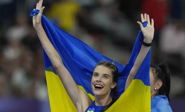 Yaroslava Mahuchikh, of Ukraine, celebrates winning the gold medal in women's high jump at the 2024 Summer Olympics, Sunday, Aug. 4, 2024, in Saint-Denis, France. (AP Photo/Rebecca Blackwell)