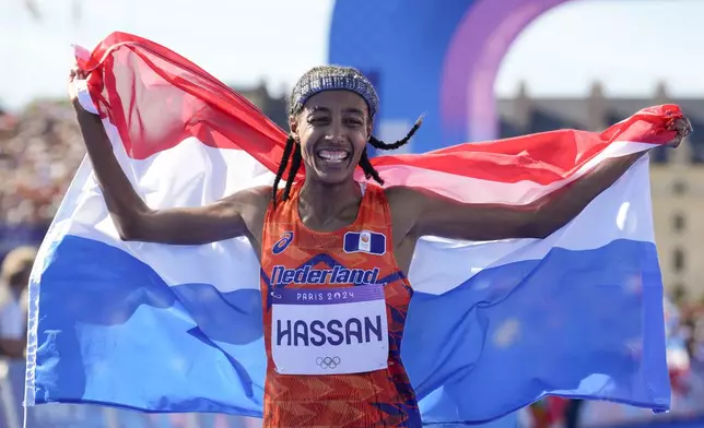 Sifan Hassan, of the Netherlands, celebrates after crossing the finish line to win the gold medal at the end of the women's marathon competition at the 2024 Summer Olympics, Sunday, Aug. 11, 2024, in Paris, France. (AP Photo/Vadim Ghirda)