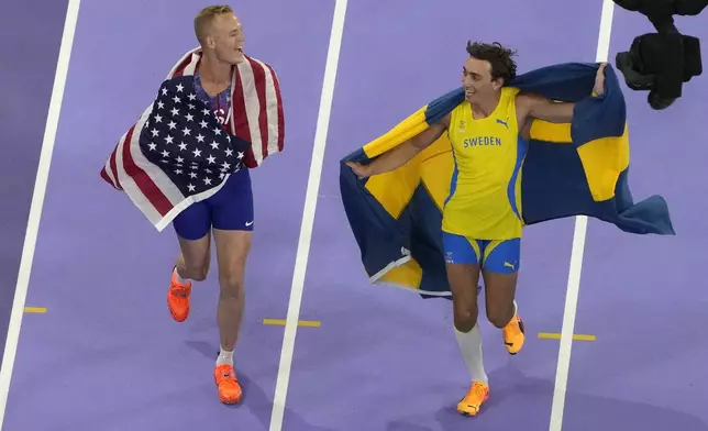 Sam Kendricks, of the United States, left, and Armand Duplantis, of Sweden, celebrate after the men's pole vault final at the 2024 Summer Olympics, Monday, Aug. 5, 2024, in Saint-Denis, France. (AP Photo/David J. Phillip)