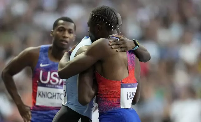 Gold medalist Letsile Tebogo, of Botswana, and bronze medalist Noah Lyles, of the United States, foreground, embrace each other after finishing the men's 200 meters final at the 2024 Summer Olympics, Thursday, Aug. 8, 2024, in Saint-Denis, France. (AP Photo/Ashley Landis)
