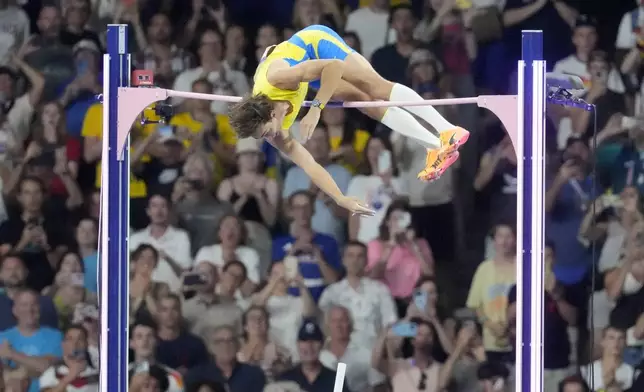 Armand Duplantis, of Sweden, clears the bar at 6.25 to set a new world record during the men's pole vault final at the 2024 Summer Olympics, Monday, Aug. 5, 2024, in Saint-Denis, France. (AP Photo/Martin Meissner)