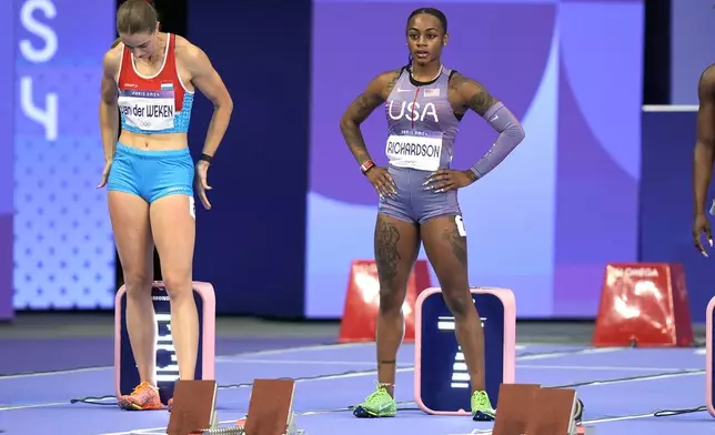 Sha'carri Richardson, right, of the United States, prepares to start in her women's 100-meter semifinal at the 2024 Summer Olympics, Saturday, Aug. 3, 2024, in Saint-Denis, France. (AP Photo/Matthias Schrader)