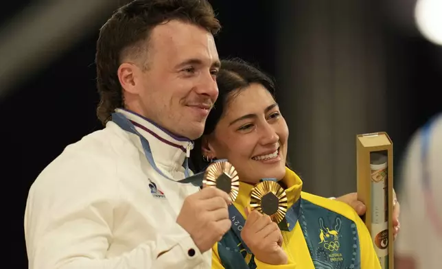 Bronze medallist Romain Mahieu of France, left, poses with gold medallist Saya Sakakibara of Australia, after the men's and women's BMX racing events, at the 2024 Summer Olympics, Friday, Aug. 2, 2024, in Saint-Quentin-en-Yvelines, France. (AP Photo/Ricardo Mazalan)