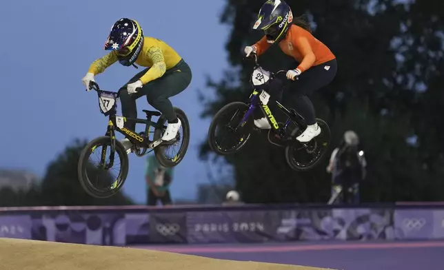 Saya Sakakibara of Australia, left, and Merel Smulders of Netherlands compete in a BMX racing event, at the 2024 Summer Olympics, Friday, Aug. 2, 2024, in Saint-Quentin-en-Yvelines, France. (AP Photo/Thibault Camus)