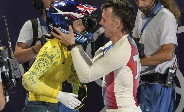 Saya Sakakibara of Australia, left, is congratulated by bronze medal's winner Romain Mahieu of France after the BMX men's and women's racing events at the 2024 Summer Olympics, Friday, Aug. 2, 2024, in Saint-Quentin-en-Yvelines, France. (AP Photo/Thibault Camus)