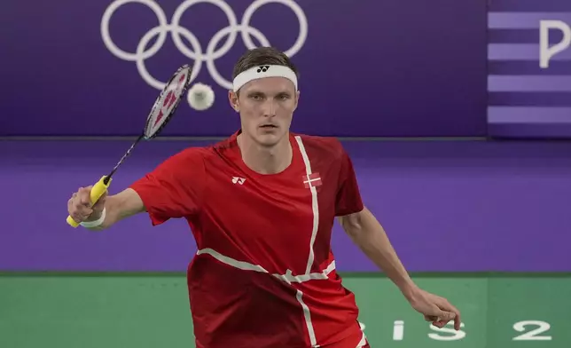 Denmark's Viktor Axelsen plays against Thailand's Kunlavut Vitidsarn during their men's singles badminton gold medal match at the 2024 Summer Olympics, Monday, Aug. 5, 2024, in Paris, France. (AP Photo/Kin Cheung)