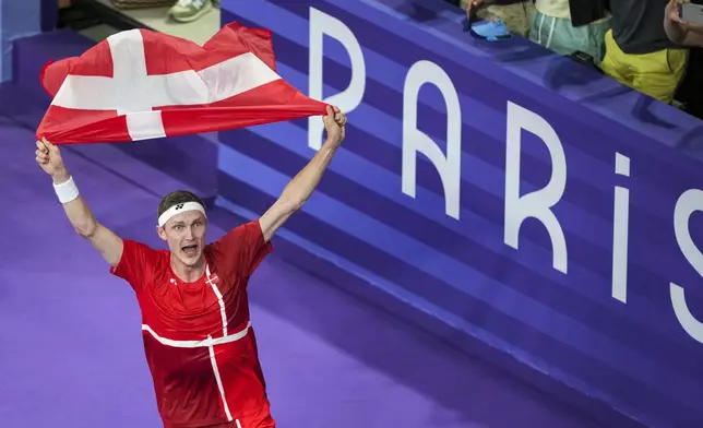 Denmark's Viktor Axelsen celebrates after defeating Thailand's Kunlavut Vitidsarn during their men's singles badminton gold medal match at the 2024 Summer Olympics, Monday, Aug. 5, 2024, in Paris, France. (AP Photo/Kin Cheung)