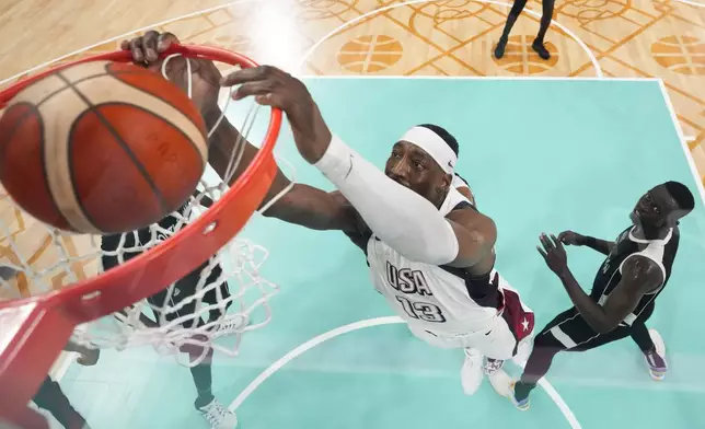 Bam Adebayo, of the United States, puts in a basket in front of Peter Jok, of South Sudan, in a men's basketball game at the 2024 Summer Olympics, Wednesday, July 31, 2024, in Villeneuve-d'Ascq, France. (AP Photo/Mark J. Terrill, Pool)