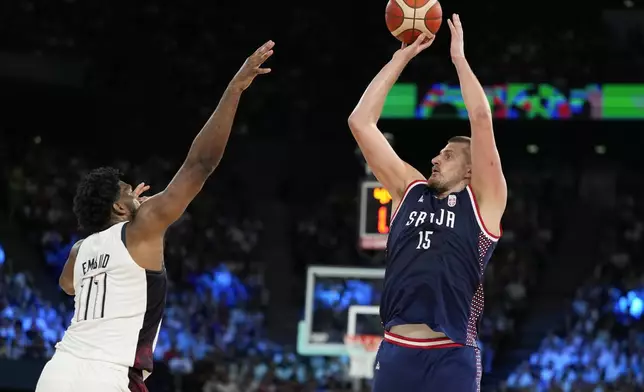 Nikola Jokic (15), of Serbia shoots over United States' Joel Embiid (11) during a men's semifinals basketball game at Bercy Arena at the 2024 Summer Olympics, Thursday, Aug. 8, 2024, in Paris, France. (AP Photo/Michael Conroy)