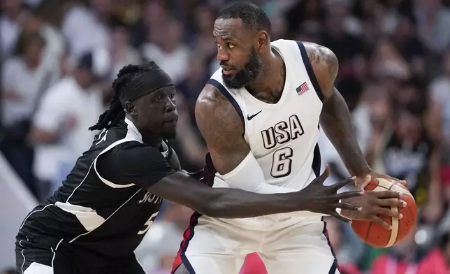 Nuni Omot, of South Sudan, defends LeBron James, of the United States, in a men's basketball game at the 2024 Summer Olympics, Wednesday, July 31, 2024, in Villeneuve-d'Ascq, France. (AP Photo/Mark J. Terrill)