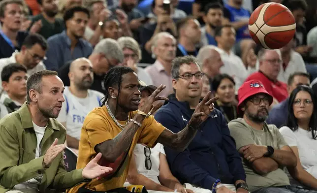 Travis Scott tosses the ball back in before the France vs' Germany game during a men's semifinals basketball game at Bercy Arena at the 2024 Summer Olympics, Thursday, Aug. 8, 2024, in Paris, France. (AP Photo/Mark J. Terrill)