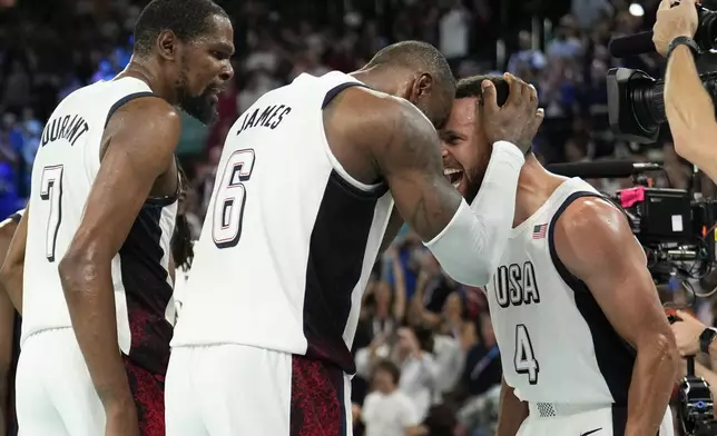 United States' Kevin Durant (7), LeBron James (6) and Steph Curry (4) celebrate after beating Serbia during a men's semifinals basketball game at Bercy Arena at the 2024 Summer Olympics, Thursday, Aug. 8, 2024, in Paris, France. (AP Photo/Mark J. Terrill)