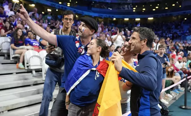 Tony Estanguet, President of the Paris 2024 Organising Committee, poses with fans during a women's basketball game between Nigeria and France at the 2024 Summer Olympics, Thursday, Aug. 1, 2024, in Villeneuve-d'Ascq, France. (AP Photo/Michael Conroy)