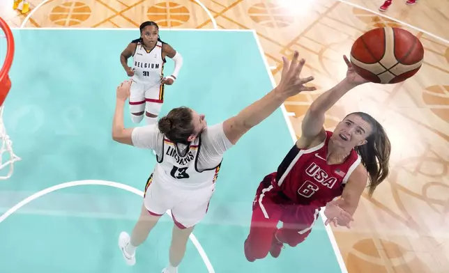 United States' Sabrina Ionescu, right, shoots as Belgium's Kyara Linskens, center, defends in a women's basketball game at the 2024 Summer Olympics, Thursday, Aug. 1, 2024, in Villeneuve-d'Ascq, France. (AP Photo/Michael Conroy, Pool)