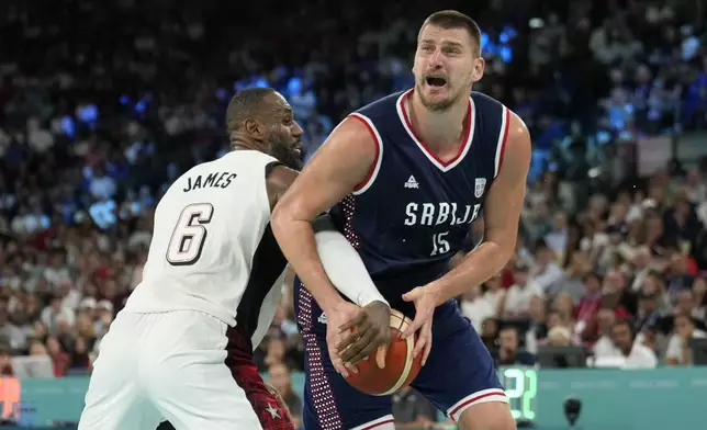 Nikola Jokic (15), of Serbia drives to the basket against United States' LeBron James (6) during a men's semifinals basketball game at Bercy Arena at the 2024 Summer Olympics, Thursday, Aug. 8, 2024, in Paris, France. (AP Photo/Mark J. Terrill)