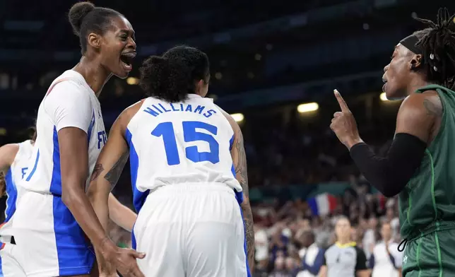 France's Valeriane Ayayi, left, celebrates after scoring and drawing a foul as Nigeria's Amy Ezinne Kalu has words with her with France's Gabby Williams between them during a women's basketball game at the 2024 Summer Olympics, Thursday, Aug. 1, 2024, in Villeneuve-d'Ascq, France. (AP Photo/Michael Conroy)