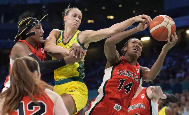 Canada's Aaliyah Edwards, left, and Canada's Kayla Alexander, right, reach for a rebound along with Australia's Steph Talbot during a women's basketball game at the 2024 Summer Olympics, Thursday, Aug. 1, 2024, in Villeneuve-d'Ascq, France. (AP Photo/Michael Conroy)