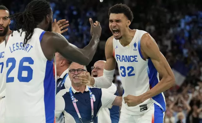 Mathias Lessort (26), of France and Victor Wembanyama (32), of France celebrate after beating Germany during a men's semifinals basketball game at Bercy Arena at the 2024 Summer Olympics, Thursday, Aug. 8, 2024, in Paris, France. (AP Photo/Mark J. Terrill)