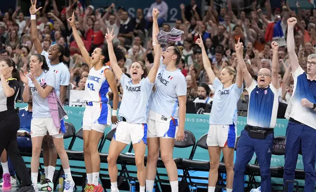 France team members celebrate from the bench after France scored a three-point basket during a women's basketball game at the 2024 Summer Olympics, Thursday, Aug. 1, 2024, in Villeneuve-d'Ascq, France. (AP Photo/Michael Conroy)