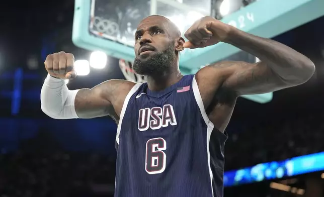 United States' LeBron James flexes after scoring during a men's basketball game against Brazil at the 2024 Summer Olympics, Tuesday, Aug. 6, 2024, in Paris, France. (AP Photo/Michael Conroy)