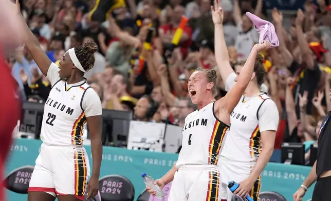 Belgium's Elisa Ramette, center, celebrates with teammates from the bench after they scored during a women's basketball game against the United States at the 2024 Summer Olympics, Thursday, Aug. 1, 2024, in Villeneuve-d'Ascq, France. (AP Photo/Michael Conroy)