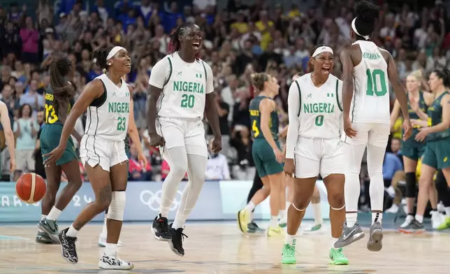 Nigerian players, left to right, Ezinne Kalu, Murjanatu Musa, Amy Okonkwo, of Nigeria, and Promise Amukamara, celebrate after Nigeria defeated Australia in a women's basketball game at the 2024 Summer Olympics, Monday, July 29, 2024, in Villeneuve-d'Ascq, France. (AP Photo/Mark J. Terrill)