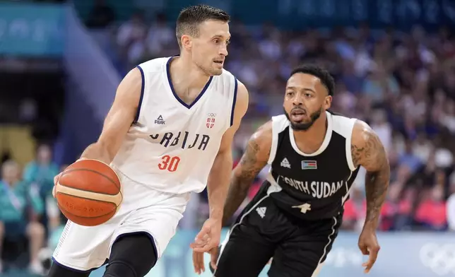 Serbia's Aleksa Avramovic, left, drive spas South Sudan's Carlik Jones during a men's basketball game at the 2024 Summer Olympics, Saturday, Aug. 3, 2024, in Villeneuve-d'Ascq, France. (AP Photo/Michael Conroy)