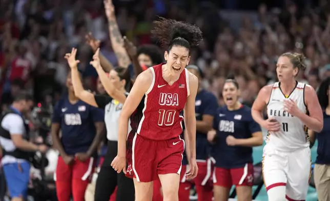 United States' Breanna Stewart, center, celebrates after scoring as Belgium's Emma Meesseman, right, runs along during a women's basketball game at the 2024 Summer Olympics, Thursday, Aug. 1, 2024, in Villeneuve-d'Ascq, France. (AP Photo/Michael Conroy)