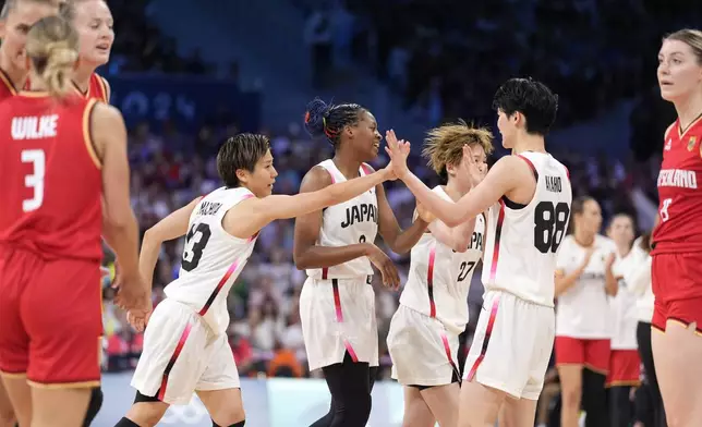 Japan's Rui Machida, fourth from left, celebrates with teammates after hitting a three point shot during a women's basketball game against Germany at the 2024 Summer Olympics, Thursday, Aug. 1, 2024, in Villeneuve-d'Ascq, France. (AP Photo/Michael Conroy)