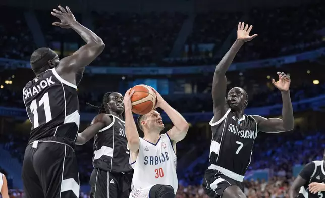 Serbia's Aleksa Avramovic, second from right, shoots as South Sudan's Marial Shayok, left, South Sudan's Wenyen Gabriel, second from left, and South Sudan's Bul Kuol defend during a men's basketball game at the 2024 Summer Olympics, Saturday, Aug. 3, 2024, in Villeneuve-d'Ascq, France. (AP Photo/Michael Conroy)