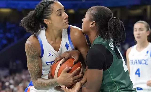 France's Gabby Williams, left, and Nigeria's Amy Elizabeth Balogun tie up the ball during a women's basketball game at the 2024 Summer Olympics, Thursday, Aug. 1, 2024, in Villeneuve-d'Ascq, France. (AP Photo/Michael Conroy)