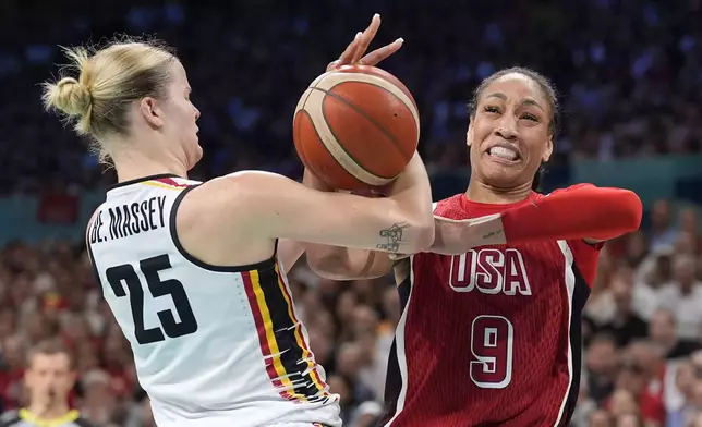 Belgium's Beckey Massey, left, and United States' A'ja Wilson grapple for the ball during a women's basketball game at the 2024 Summer Olympics, Thursday, Aug. 1, 2024, in Villeneuve-d'Ascq, France. (AP Photo/Michael Conroy)