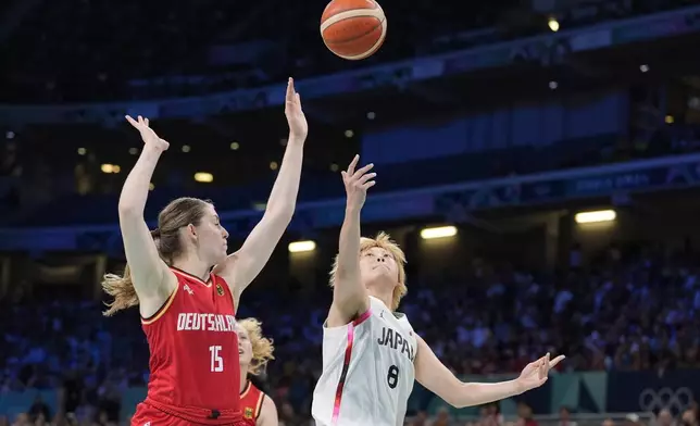 Japan's Maki Takada, right, shoots as Germany's Luisa Geiselsoder defends during a women's basketball game at the 2024 Summer Olympics, Thursday, Aug. 1, 2024, in Villeneuve-d'Ascq, France. (AP Photo/Michael Conroy)