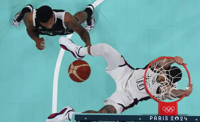 Jayson Tatum, of the United States, gets a dunk over Carlik Jones, of South Sudan, at the 2024 Summer Olympics, Wednesday, July 31, 2024, in Villeneuve-d'Ascq, France. (Brian Snyder/Pool Photo via AP)