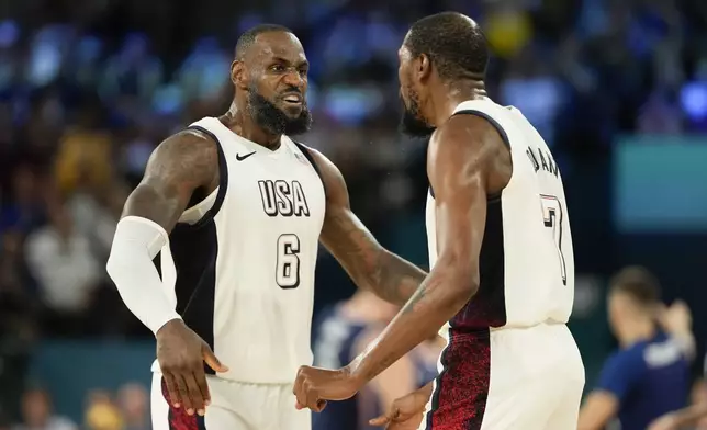 United States' LeBron James (6) and Kevin Durant (7) celebrate a basket against Serbia during a men's semifinals basketball game at Bercy Arena at the 2024 Summer Olympics, Thursday, Aug. 8, 2024, in Paris, France. (AP Photo/Mark J. Terrill)