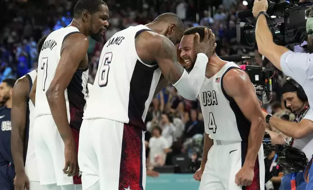 United States' Kevin Durant (7), LeBron James (6) and Steph Curry (4) celebrate after beating Serbia during a men's semifinals basketball game at Bercy Arena at the 2024 Summer Olympics, Thursday, Aug. 8, 2024, in Paris, France. (AP Photo/Mark J. Terrill)