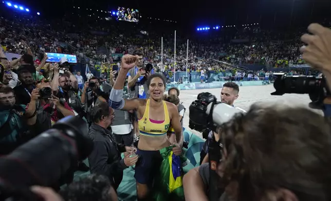 Brazil's Ana Patricia Silva Ramos celebrates as Brazil defeats Canada in the women's beach volleyball gold medal match, at the 2024 Summer Olympics, Friday, Aug. 9, 2024, in Paris, France. (AP Photo/Robert F. Bukaty)