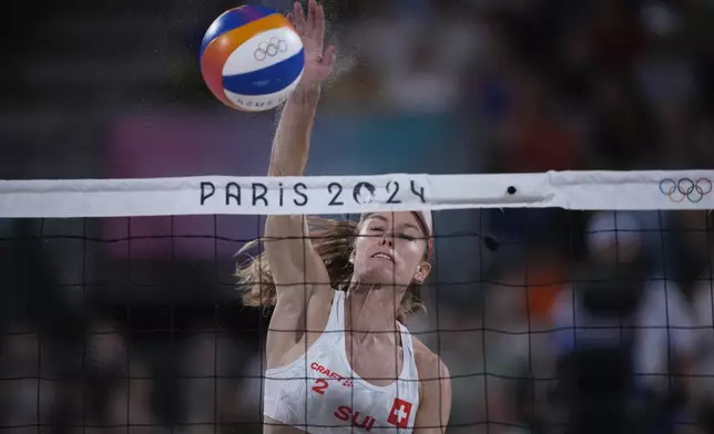 Switzerland's Nina Brunner hits the ball in the women's beach volleyball bronze medal match between Australia and Switzerland, at the 2024 Summer Olympics, Friday, Aug. 9, 2024, in Paris, France. (AP Photo/Louise Delmotte)
