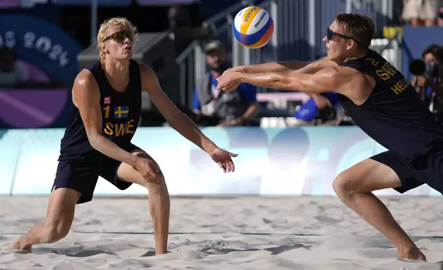 Sweden's David Ahmad, left, watches Jonatan Hellvig return a shot in a quarterfinal beach volleyball match against Brazil at the 2024 Summer Olympics, Tuesday, Aug. 6, 2024, in Paris, France. (AP Photo/Robert F. Bukaty)