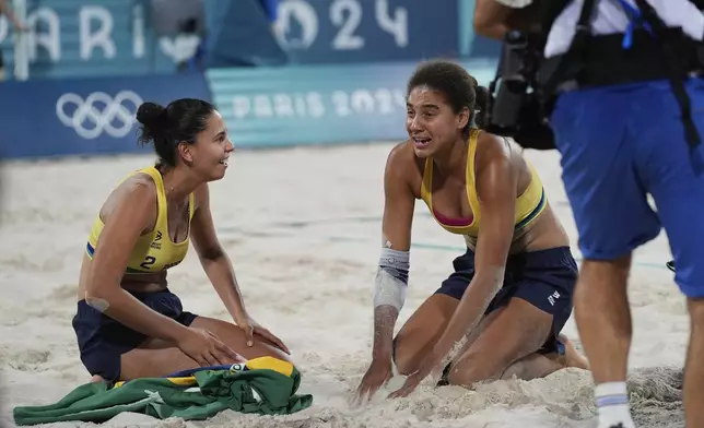 Brazil's Eduarda "Duda" Santos Lisboa, left, and Ana Patricia Silva Ramos react after winning their women's beach volleyball gold medal match against Canada, at the 2024 Summer Olympics, Friday, Aug. 9, 2024, in Paris, France. (AP Photo/Robert F. Bukaty)