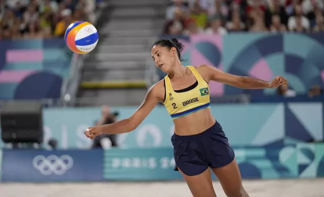 Brazil's Eduarda "Duda" Santos Lisboa misses a shot in the women's beach volleyball gold medal match between Brazil and Canada, at the 2024 Summer Olympics, Friday, Aug. 9, 2024, in Paris, France. (AP Photo/Robert F. Bukaty)
