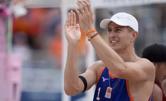 The Netherland's Steven van de Velde applauds the crowd after his team's victory against Chile in a beach volleyball match at the 2024 Summer Olympics, Wednesday, July 31, 2024, in Paris, France. Van de Velde was booed throughout the match in response to his rape conviction. (AP Photo/Robert F. Bukaty)